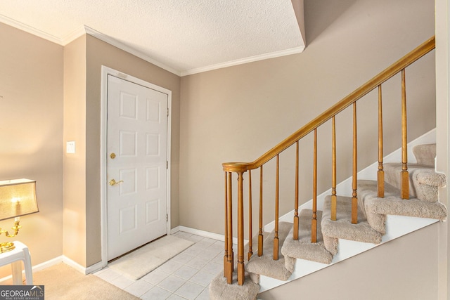 foyer entrance featuring baseboards, stairs, a textured ceiling, and crown molding