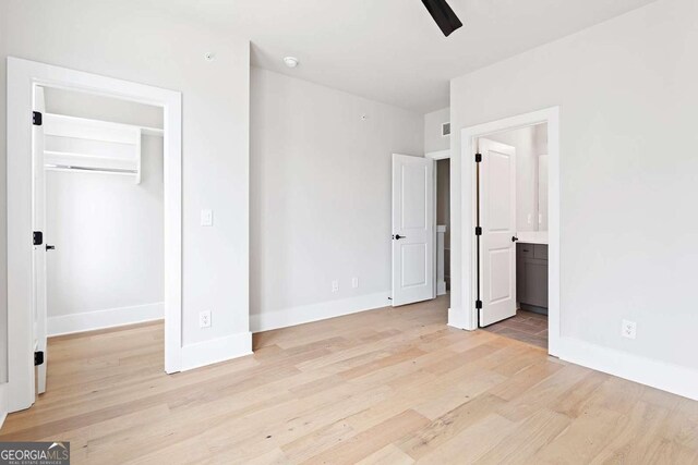 7110 Summit Pl, Alpharetta, GA 30009 - unfurnished bedroom with light wood finished floors, baseboards, a spacious closet, connected bathroom, and a closet