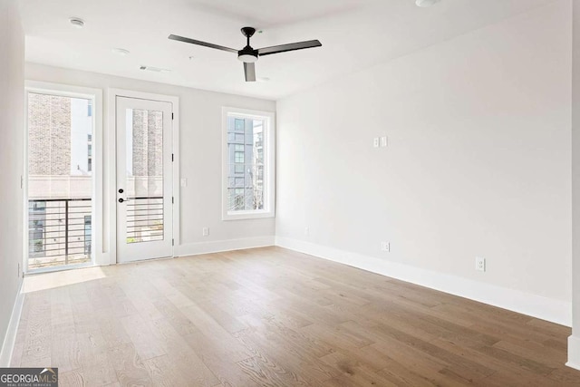 empty room featuring light wood finished floors, baseboards, and ceiling fan