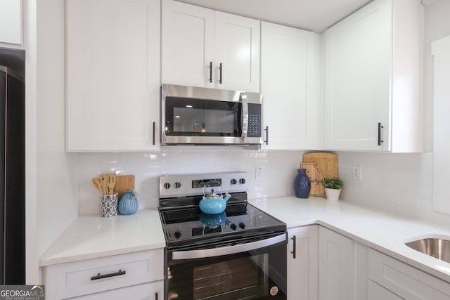 1749 Lauranceae Way, Riverdale, GA 30296 - kitchen featuring white cabinetry, light stone counters, tasteful backsplash, and appliances with stainless steel finishes