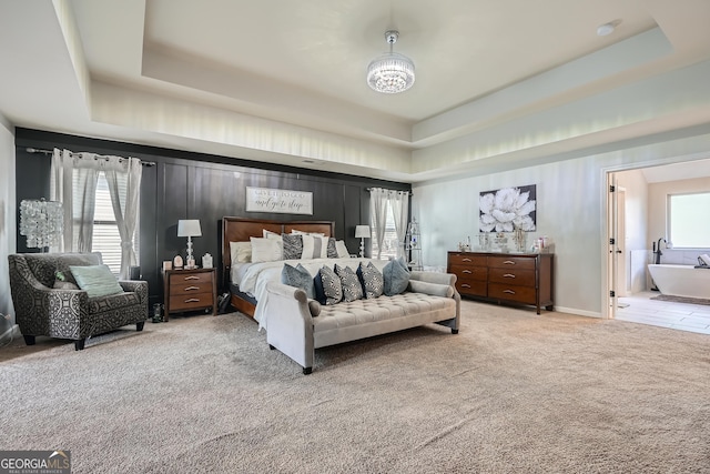 bedroom with a chandelier, a raised ceiling, and carpet floors