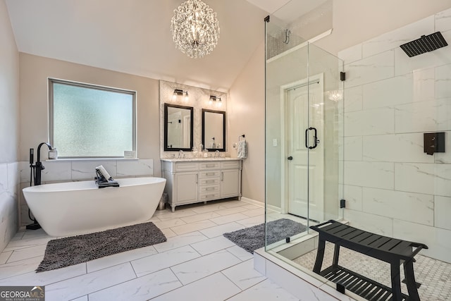 full bathroom with a stall shower, vanity, a freestanding tub, a chandelier, and marble finish floor
