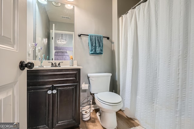 full bathroom with wood finished floors, vanity, curtained shower, toilet, and visible vents