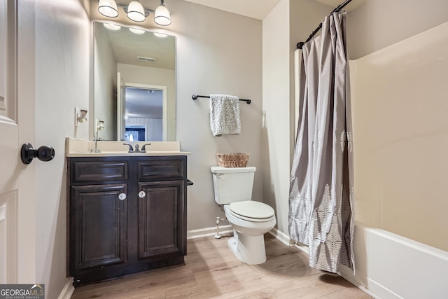 full bathroom featuring toilet, baseboards, visible vents, wood finished floors, and vanity
