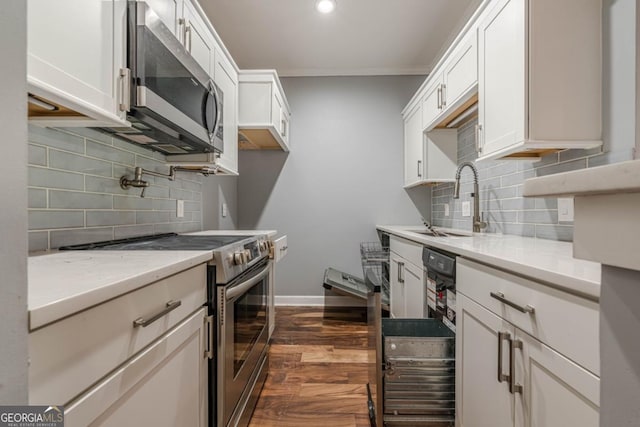 2921 Lenox Rd NE Unit 113, Atlanta, GA 30324 - kitchen featuring stainless steel appliances, dark wood-style floors, backsplash, white cabinets, and ornamental molding
