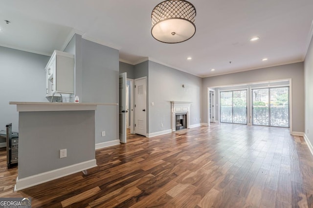2921 Lenox Rd NE Unit 113, Atlanta, GA 30324 - unfurnished living room featuring crown molding, dark wood-type flooring, a fireplace, and recessed lighting