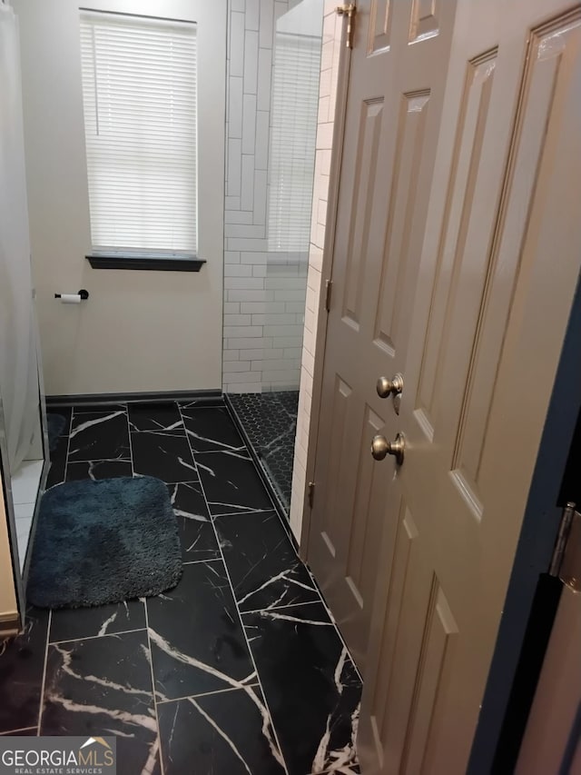 2565 Cloud, Decatur, GA 30034 - bathroom featuring marble finish floors, a tile shower, and baseboards