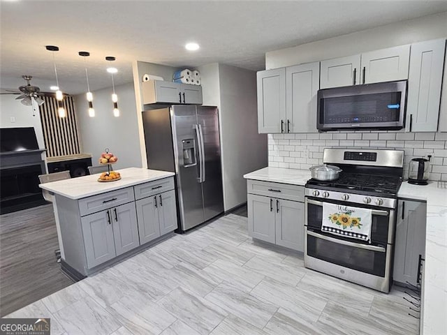 2565 Cloud, Decatur, GA 30034 - kitchen featuring stainless steel appliances, gray cabinets, a ceiling fan, tasteful backsplash, and hanging light fixtures