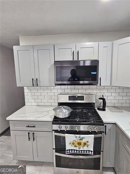2565 Cloud, Decatur, GA 30034 - kitchen with stainless steel appliances, gray cabinets, light stone counters, and backsplash