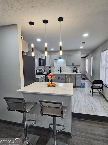 2565 Cloud, Decatur, GA 30034 - kitchen with stove, black microwave, freestanding refrigerator, gray cabinetry, and stainless steel dishwasher