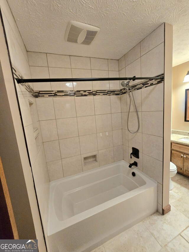 bathroom featuring toilet, vanity, bathing tub / shower combination, a textured ceiling, and visible vents