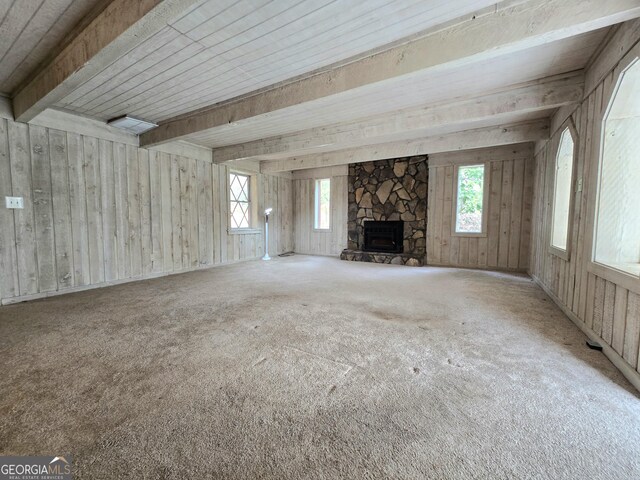 unfurnished living room featuring carpet flooring, a fireplace, and beam ceiling