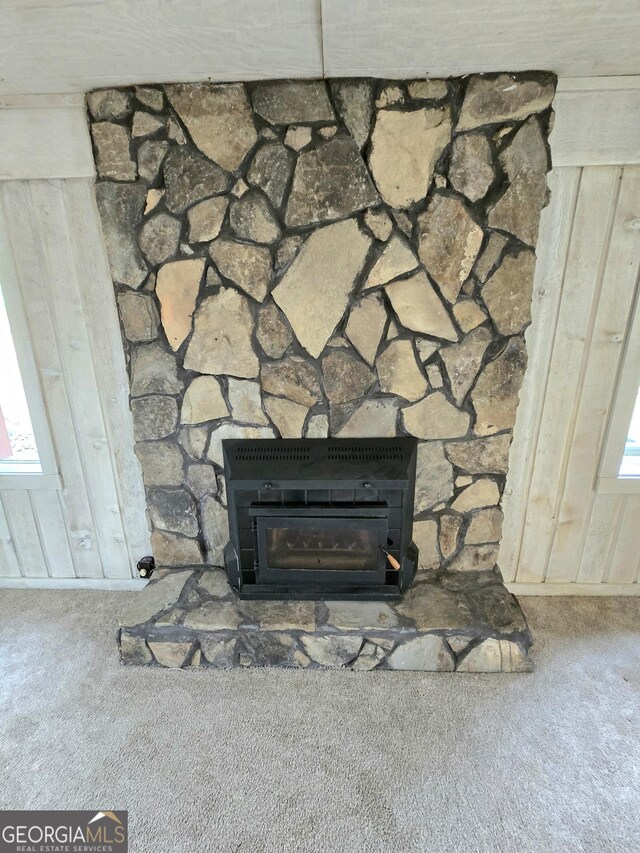 details with carpet flooring and a stone fireplace