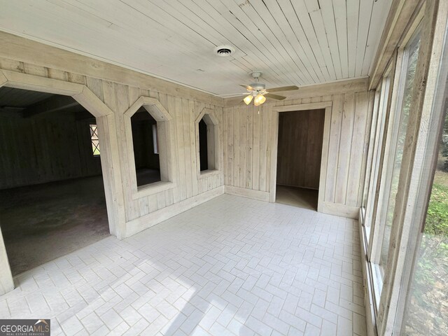 interior space featuring visible vents, wood walls, ceiling fan, and wood ceiling