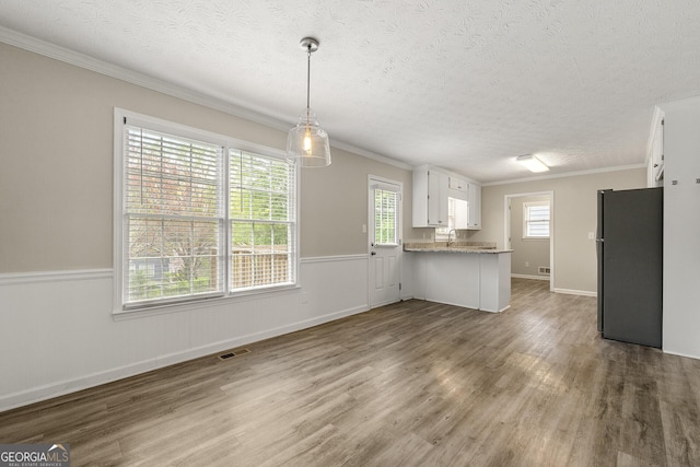kitchen with freestanding refrigerator, wood finished floors, and visible vents