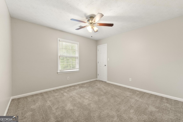 unfurnished room featuring baseboards, carpet flooring, ceiling fan, and a textured ceiling