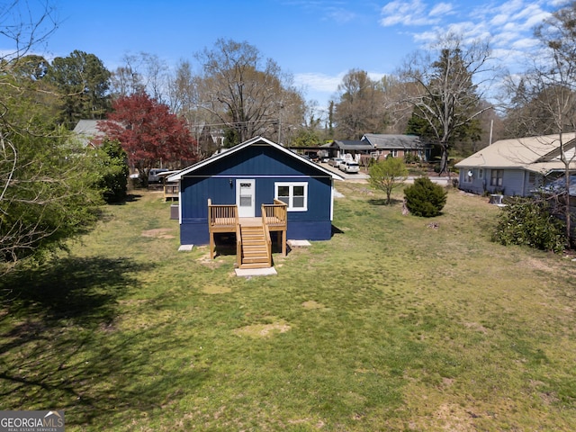 rear view of house with a deck and a yard