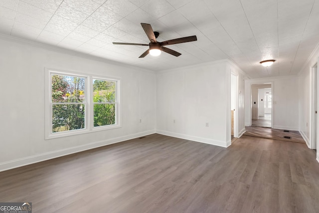 empty room with a ceiling fan, ornamental molding, baseboards, and wood finished floors