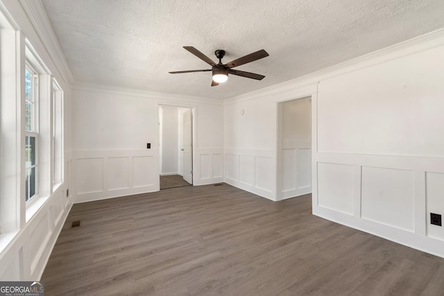 unfurnished room featuring a ceiling fan, a textured ceiling, crown molding, and visible vents