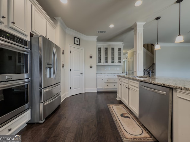 kitchen featuring white cabinets, light stone countertops, a sink, stainless steel appliances, and visible vents