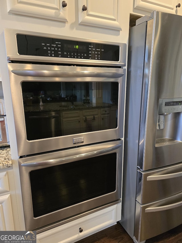 interior details featuring stainless steel appliances and white cabinetry