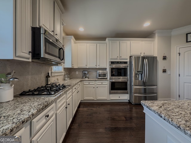 kitchen featuring crown molding, appliances with stainless steel finishes, and white cabinetry