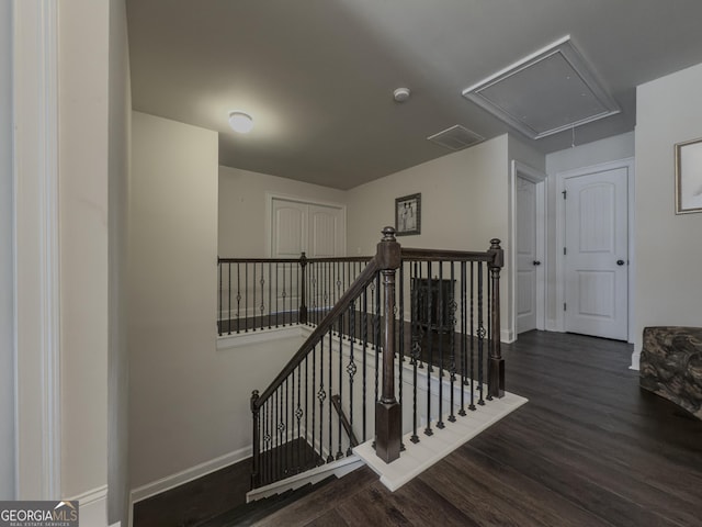 stairway featuring baseboards, attic access, and wood finished floors