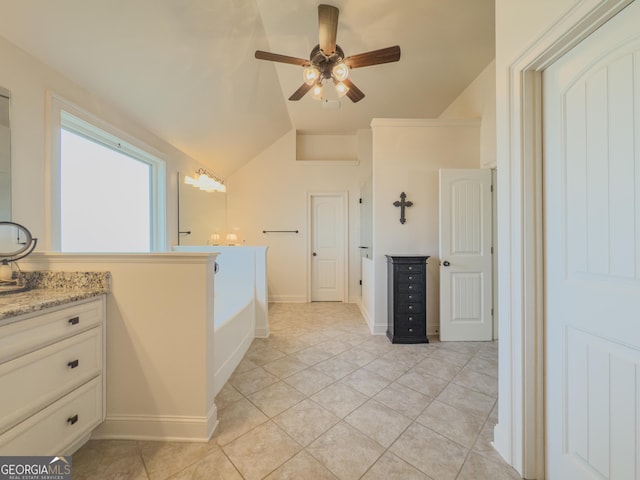 bathroom with ceiling fan, a bath, tile patterned flooring, vaulted ceiling, and vanity