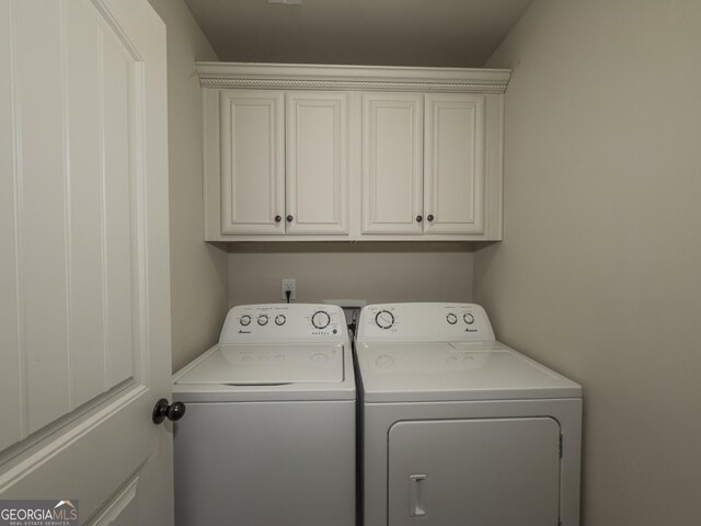 clothes washing area with cabinet space and independent washer and dryer