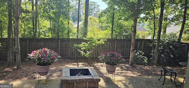 view of yard featuring an outdoor fire pit and fence