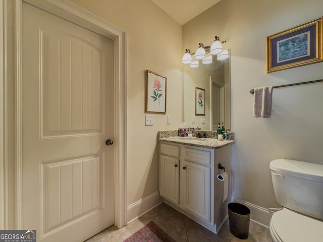 bathroom with baseboards, tile patterned floors, vanity, and toilet