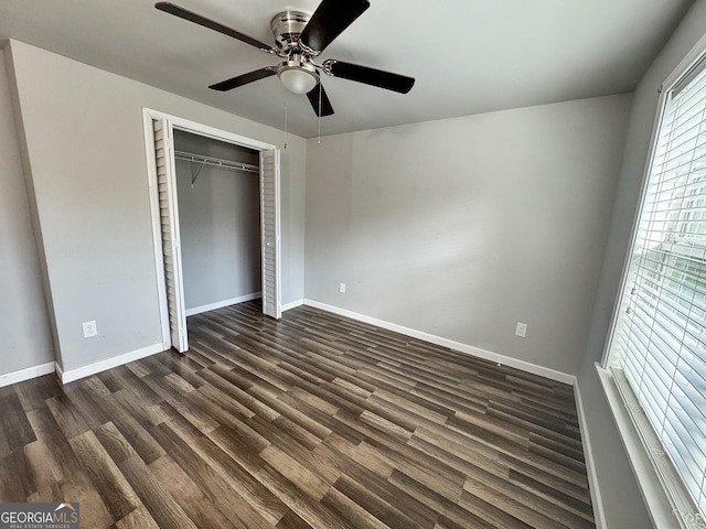 710 Bluebird Dr SE, Conyers, GA 30094 - unfurnished bedroom with baseboards, ceiling fan, a closet, and dark wood-style floors