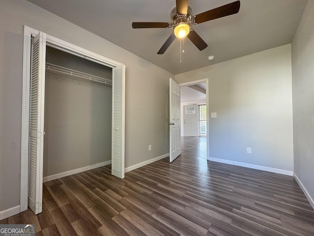 710 Bluebird Dr SE, Conyers, GA 30094 - unfurnished bedroom with baseboards, a ceiling fan, a closet, and dark wood finished floors
