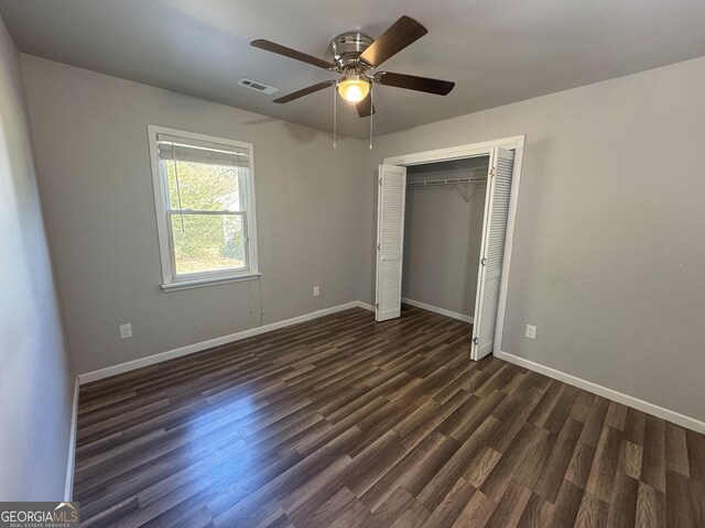 710 Bluebird Dr SE, Conyers, GA 30094 - unfurnished bedroom featuring ceiling fan, visible vents, baseboards, a closet, and dark wood-style floors