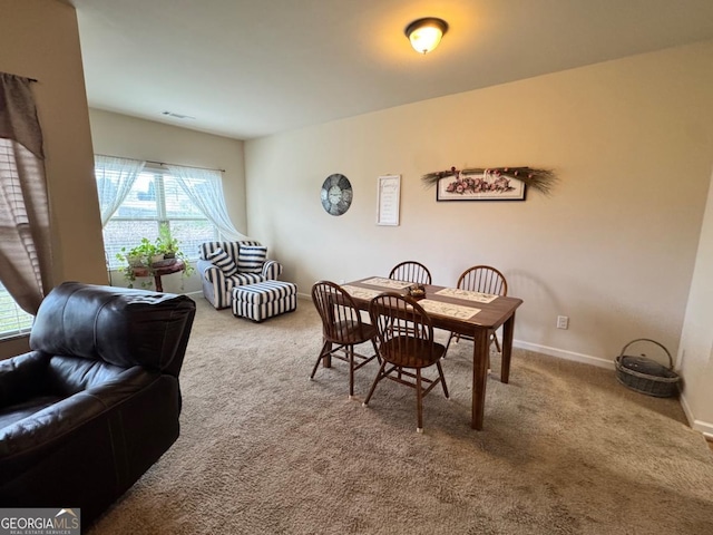 carpeted dining space with baseboards and visible vents