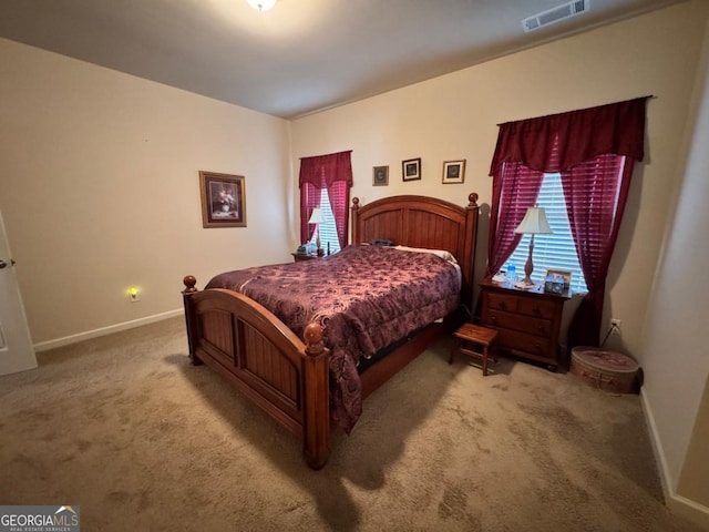 carpeted bedroom featuring baseboards, visible vents, and multiple windows