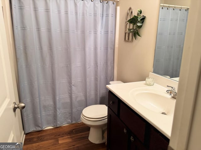 bathroom featuring wood finished floors, toilet, vanity, and a shower with curtain
