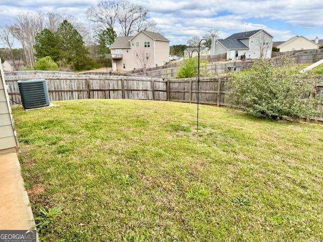 view of yard featuring a fenced backyard and central AC