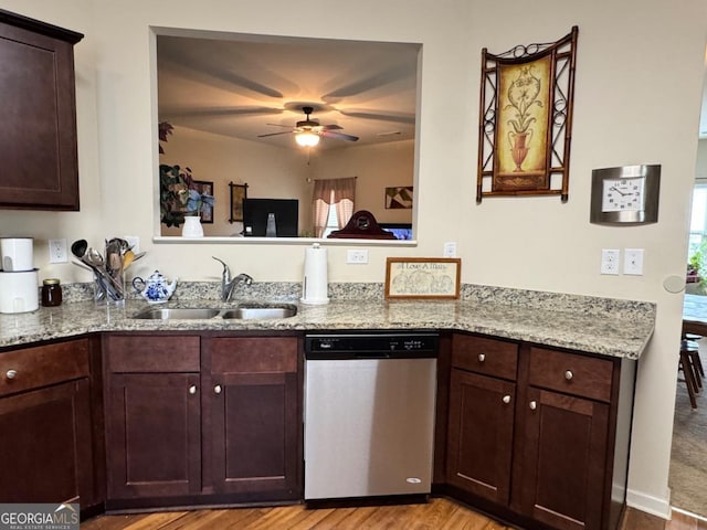 kitchen featuring dishwasher, ceiling fan, dark brown cabinets, a sink, and light stone counters