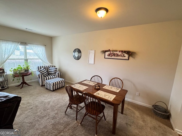 carpeted dining area with baseboards and visible vents