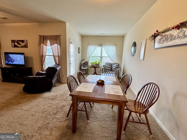 carpeted dining space with baseboards