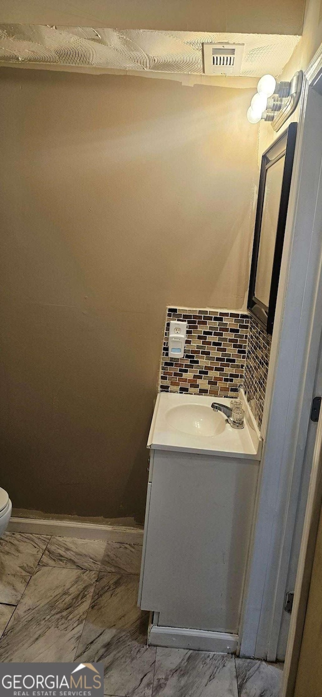 3715 Millers Pond Way, Snellville, GA 30039 - bathroom with marble finish floor, vanity, toilet, and decorative backsplash
