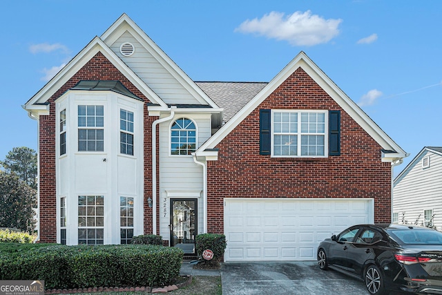 traditional-style house with an attached garage, roof with shingles, driveway, and brick siding
