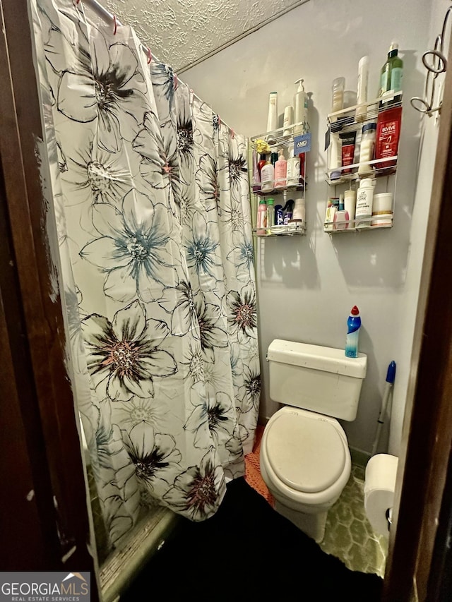 6917 Laurelwood Dr, Douglasville, GA 30135 - bathroom with a textured ceiling, toilet, and curtained shower