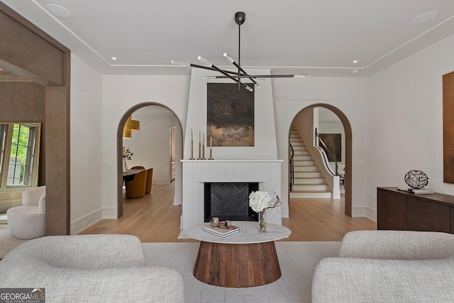 96 The Prado NE, Atlanta, GA 30309 - living area featuring a chandelier, light wood-style flooring, arched walkways, a fireplace, and recessed lighting