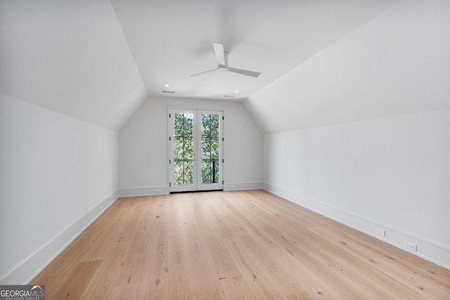 additional living space with light wood-style floors, ceiling fan, baseboards, and lofted ceiling