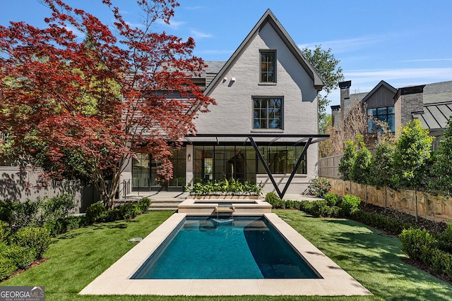 back of house featuring a yard, a pool with connected hot tub, a fenced backyard, and a patio area