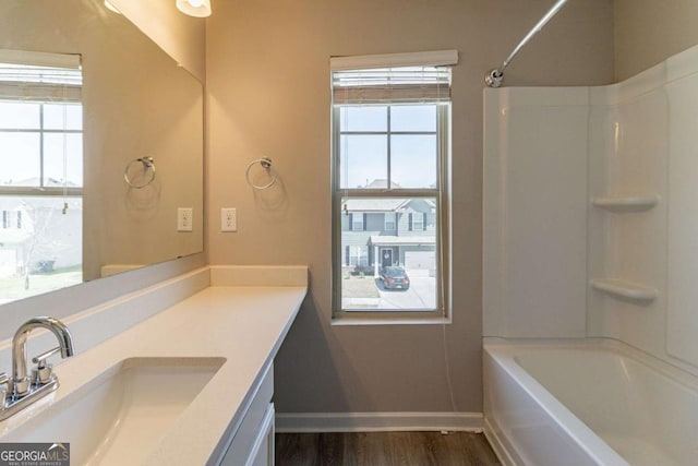 6399 Woodwell Dr, Union City, GA 30291 - bathroom with healthy amount of natural light, vanity, shower / tub combination, and wood finished floors