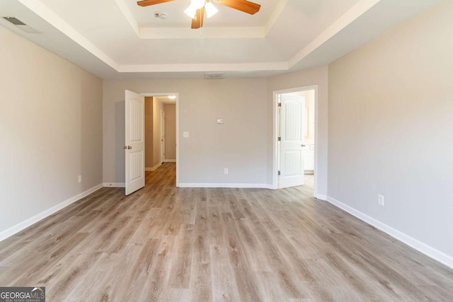 6399 Woodwell Dr, Union City, GA 30291 - empty room featuring a raised ceiling, a ceiling fan, and light wood-style floors