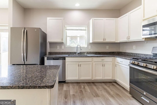 6399 Woodwell Dr, Union City, GA 30291 - kitchen with appliances with stainless steel finishes, light wood-style flooring, recessed lighting, white cabinetry, and dark stone countertops